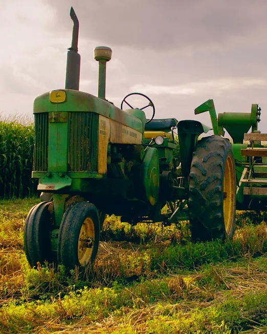 Trator em campo agrícola ao anoitecer